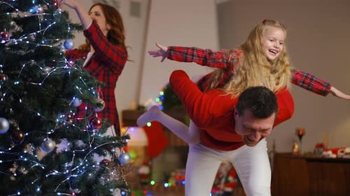 Happy Family Decorating Christmas Tree with Joy