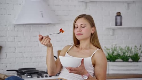 Woman Enjoying Healthy Salad in Bright Kitchen