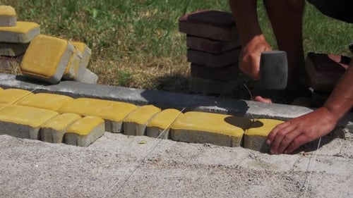 Laying Colored Tiles in a City Park