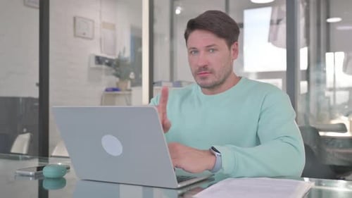 Adult Using Laptop in Modern Office Setting