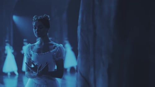 ballerina stand on stage in a frozen pose during a ballet performance.