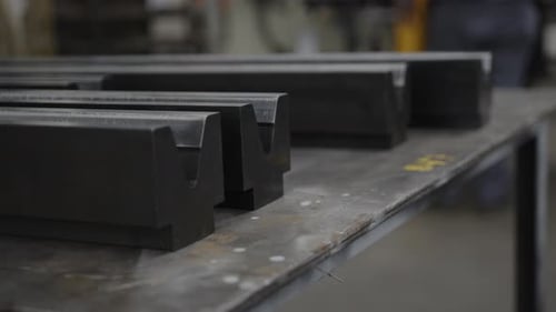 Close-up of metal profiles on a workbench in an industrial workshop, shallow depth of field