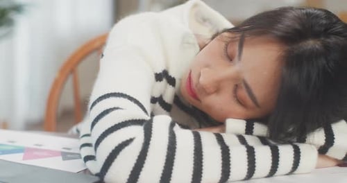 Young Adult Woman Sleeping at Desk with Laptop