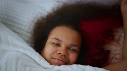 Young Adult Waking Up in Bed and Stretching