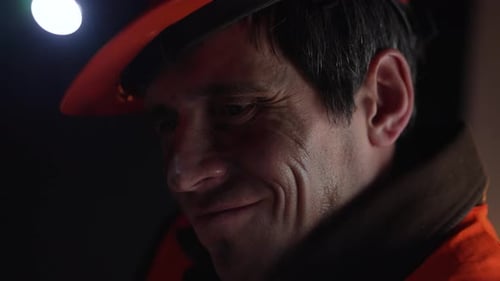 Man Wearing Hard Hat With Headlamp In the Dark