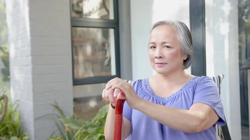 Smiling Senior Woman Holding Walking Cane on Porch