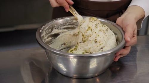 Young Woman Cook Mixing Dough with a Silicone Spatula in a Metal Bowl
