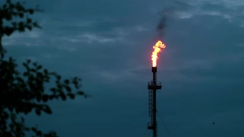 Refinery Gas Chimney Spewing Fire in a Dark and Natural Environment