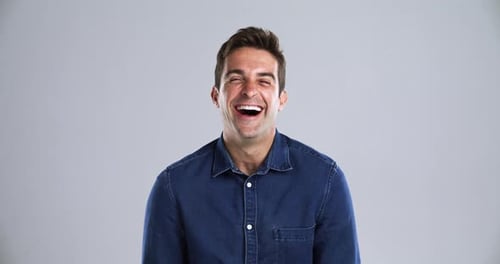 Man, face and laugh happy in studio grey background for comedy funny, joke meme or joy