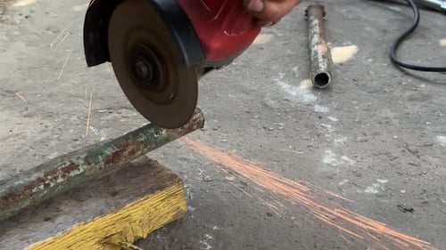Cortar un tubo de metal con una amoladora con chispas del metal