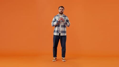 Excited Man Celebrating Success on Orange Background
