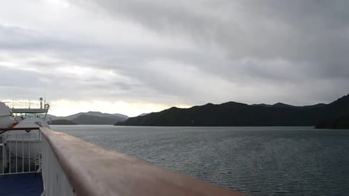 An einem ruhigen, bewölkten Abend segelt die Fähre durch die Fjorde des Queen Charlotte Sound in Neuseeland