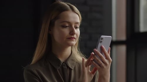 Young Woman Using Cell Phone in Modern Home