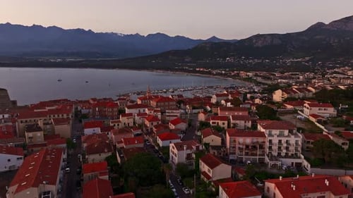 Aerial drone shot of the Citadel of Calvi in Corsica at sunrise. Warm golden hour colors. Bird's