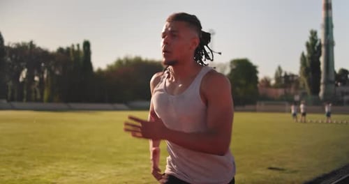Young African American Runner Athlete Jogging at the Stadium