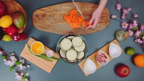 Hands Slicing Carrots with Fruits and Vegetables
