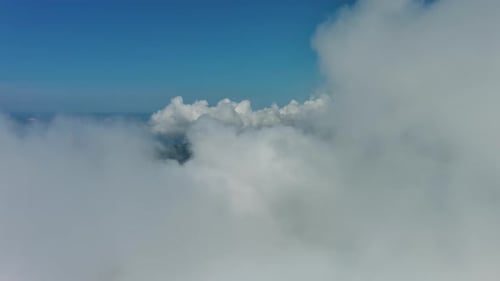 Flying Through White Clouds Over Sea