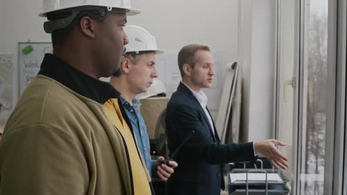Engineers Inspecting Construction Site through Office Window