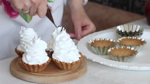 A Woman Makes A Cake Basket. Puts Chocolate From A Pastry Bag. For Buttercream Filling. Close Up.