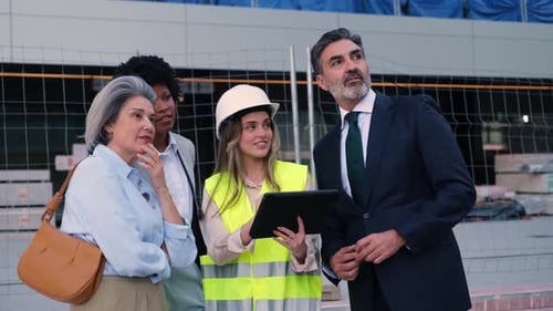 Architect showing building project to investors on tablet