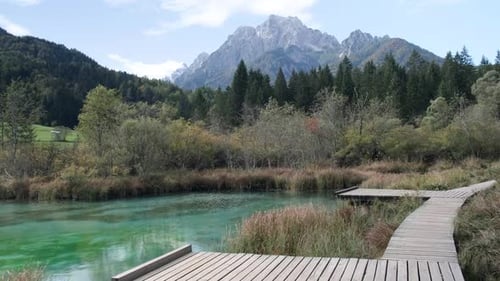 Zelenci spring in Slovenia during a beautiful sunny day looking at the alps in the background pannin