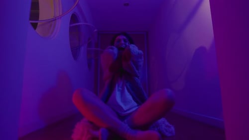 Woman Having Panic Attack and Screaming in Room with Neon Light