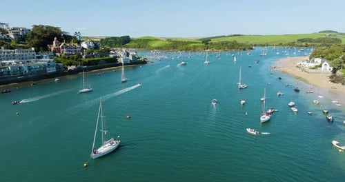 Seaside Town Popular Tourist Destination In Summer Estuary Full Of Boaters Sail Boats And Familie