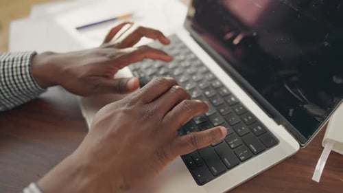 Hands Typing on Laptop Computer in Office