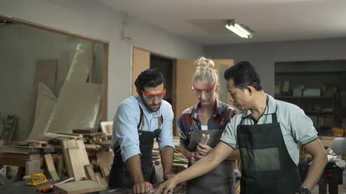 Carpenters are working together at workshop.