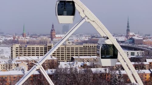 Winter Cityscape with Ferris Wheel Gondolas in Snow