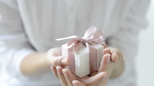 Close Up of Female Hands Holding a Small Gift Wrapped With