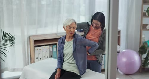Woman Receiving Back Adjustment in Physical Therapy Clinic