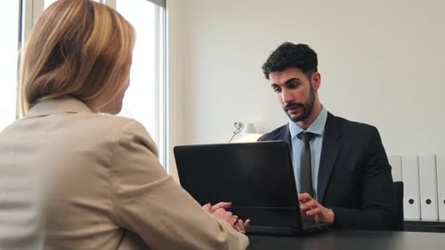 Professional Business Meeting Between a Man in a Suit and a Woman Discussing Important Matters