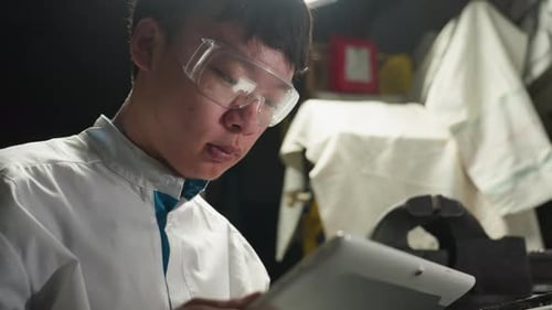 Young Engineer Using Tablet in Automotive Workshop