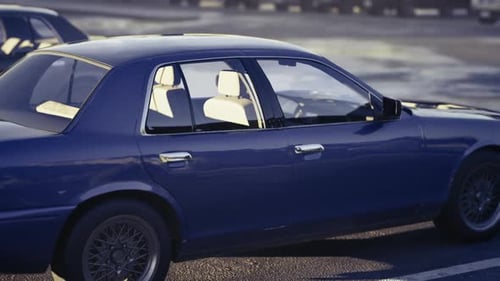 Blue Sedan Parked in Lot at Sunset