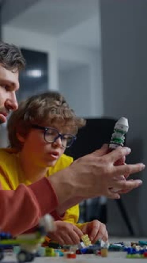 Father and Son Spending Quality Time Together Indoors Building and Assembling a Model Spacecraft
