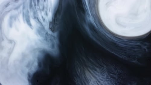 Abstract paint swirl moving across mixed black and white liquid in slow motion