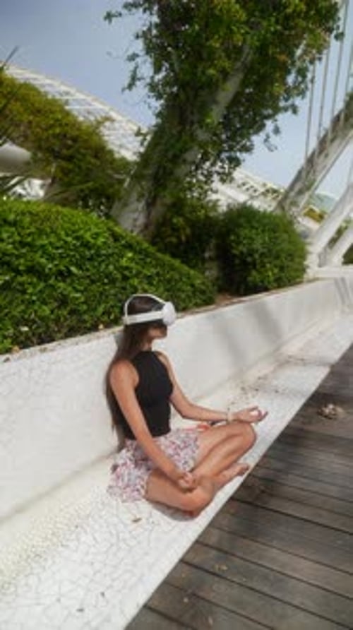 A Woman Peacefully Enjoying Modern Tech in a Virtual Reality Park Surrounded By Nature