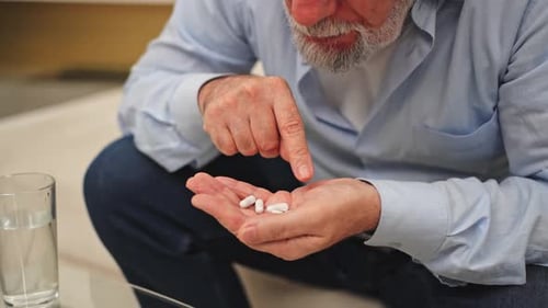 Senior Adult Examining Medication in Hand
