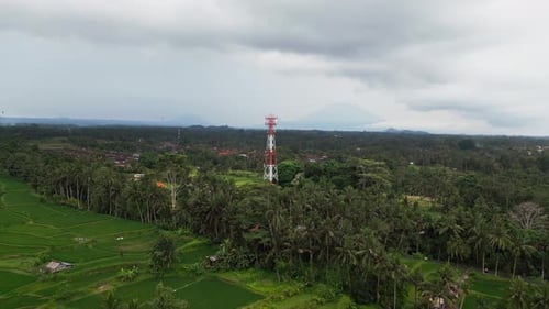 Drone Aerial View Showing Communication Tower Above Tropical Countryside with Mountains on Horizon