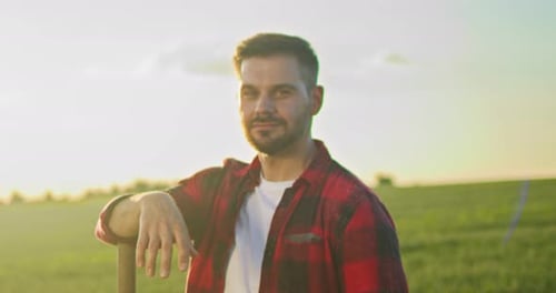 Portrait View of the Caucasian Professional Happy Farmer Holding Shovel and Standing in Backyard of