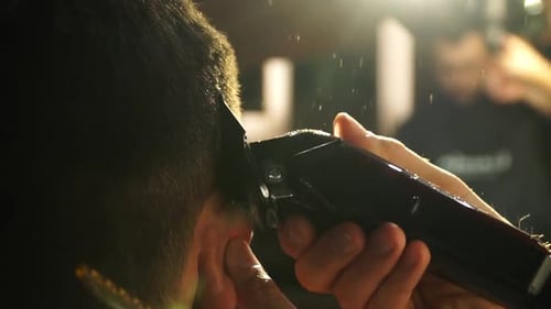 Nahaufnahme eines erfahrenen Friseurs, der mit einer Haarschneidemaschine Haare schneidet, und zeigt die Präzision und