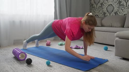 Woman Planking on Yoga Mat at Home
