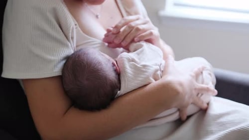 Parent Holds Newborn Baby Indoors with Love