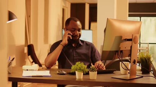 Afroamerikanischer Arbeiter telefoniert im Büro