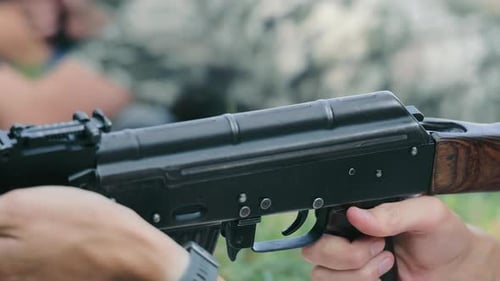 Soldier Preparing an Assault Rifle During Military Training Closeup of a Ukrainian Soldier Adjusting