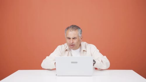 Man looking at laptop gets frustrated.