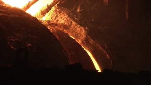 Industrial Molten Metal Pouring in Dark Steel Mill