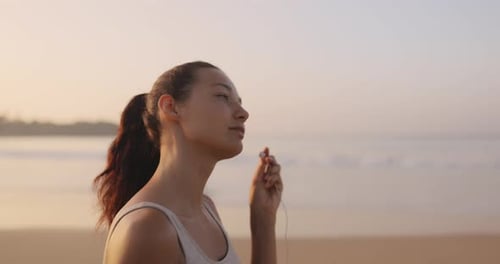 Female Runner Jogging With Earphones During Outdoor Workout on the Beach in Slow Motion