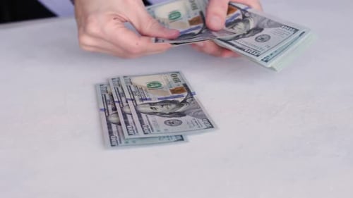 Bank Teller Counting New One Hundred Dollar Bills On White Table. - closeup